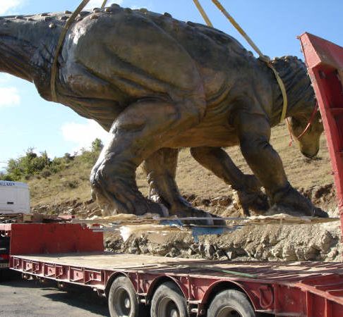 Grúas Vallarín estatua de dinosaurio sobre vehículo