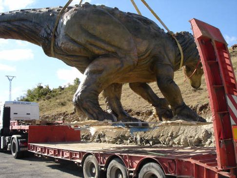 Grúas Vallarín estatua de dinosaurio sobre vehículo